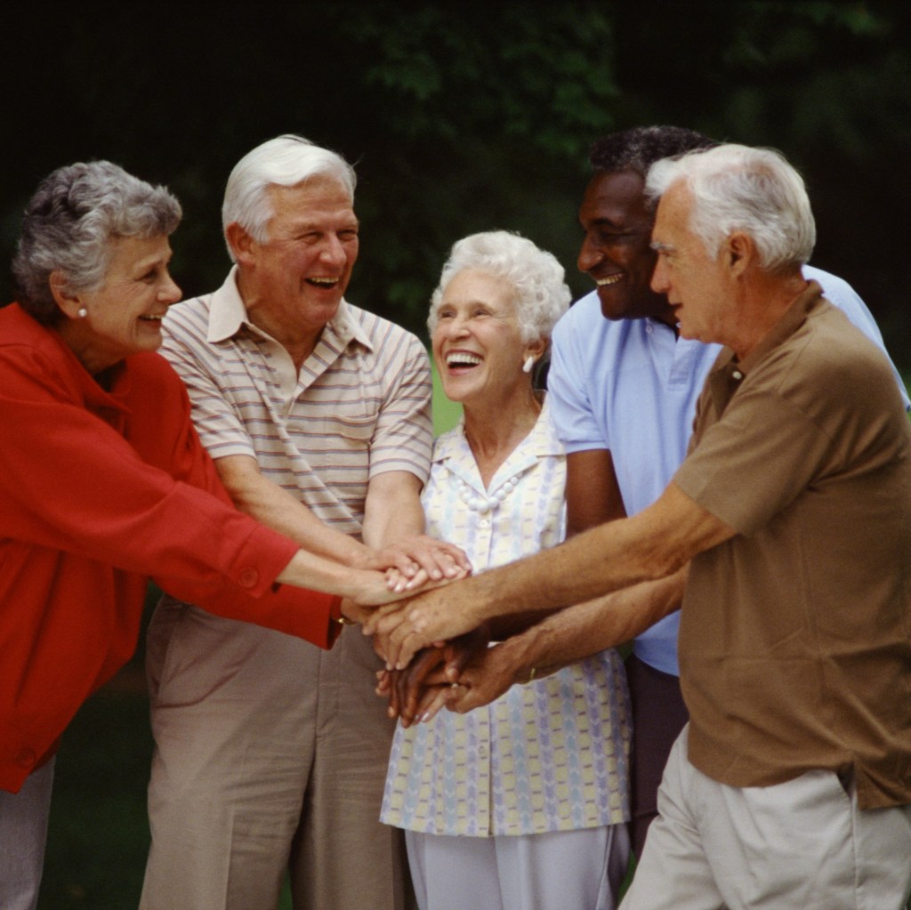 group of seniors with hands in centered circle